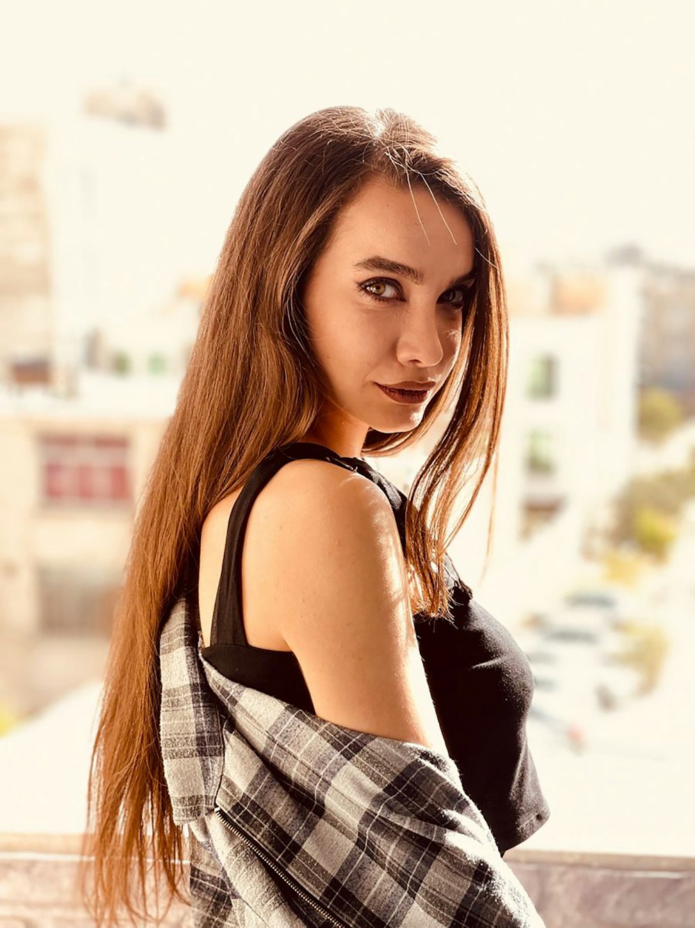 a woman posing for a picture in front of a window