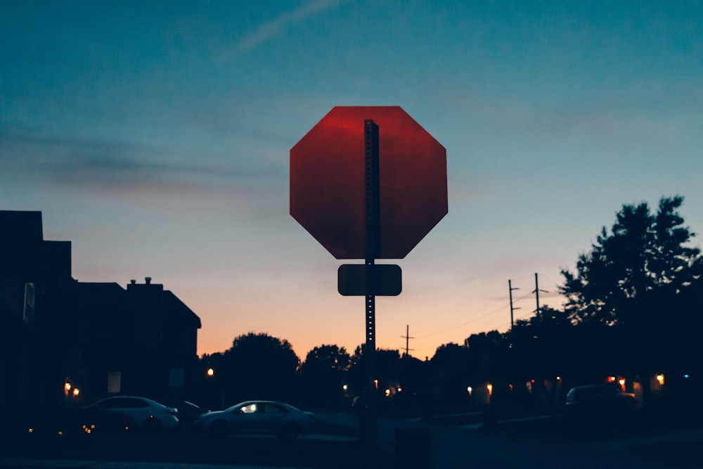 a red stop sign sitting on the side of a road