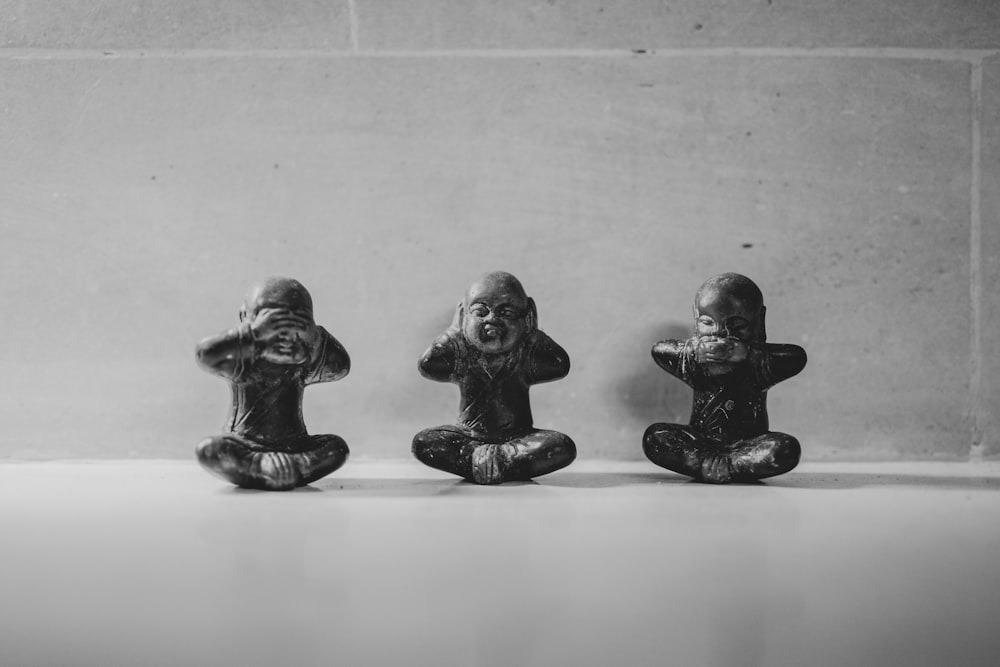 three small figurines sitting in a row