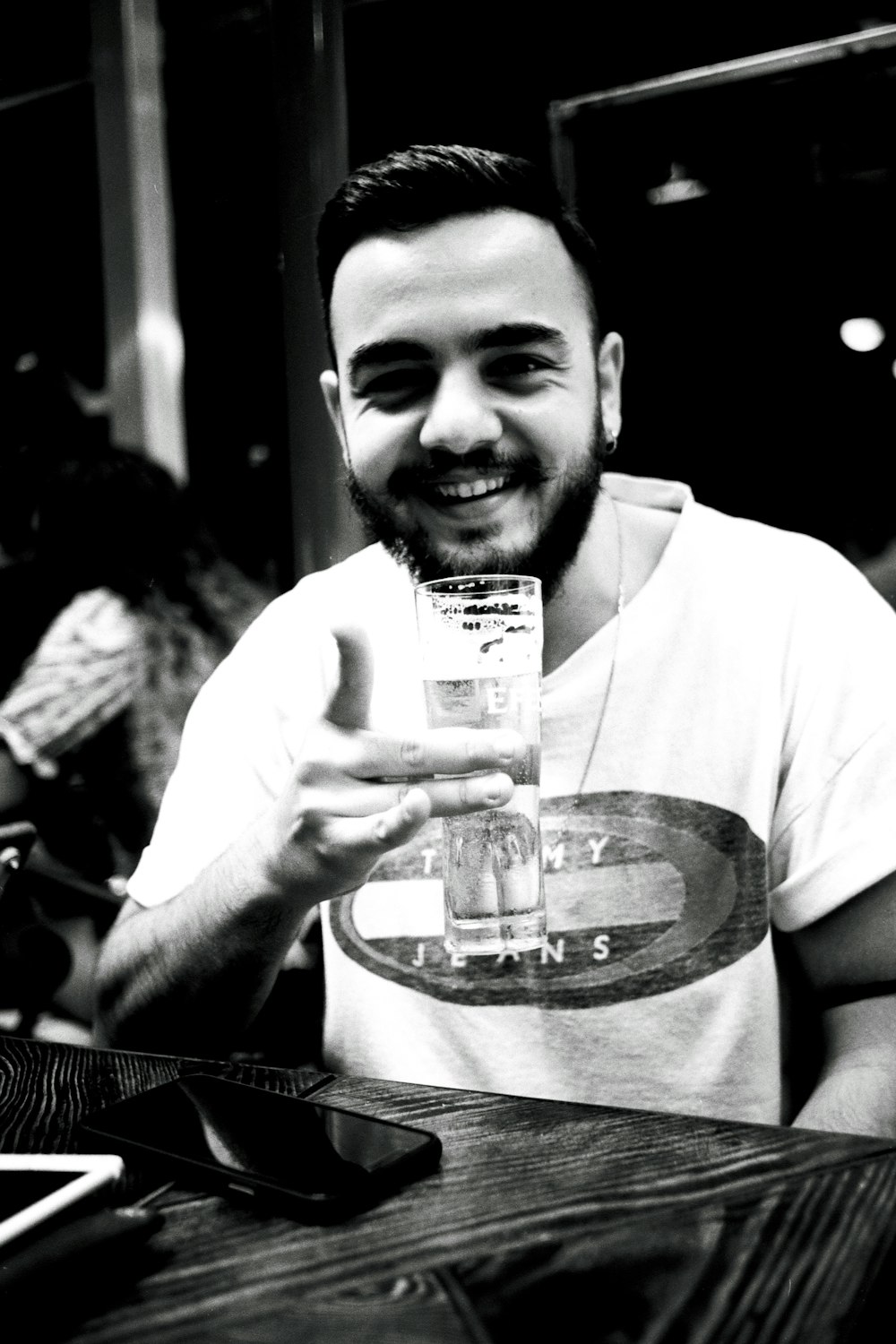 a man sitting at a table with a glass in his hand