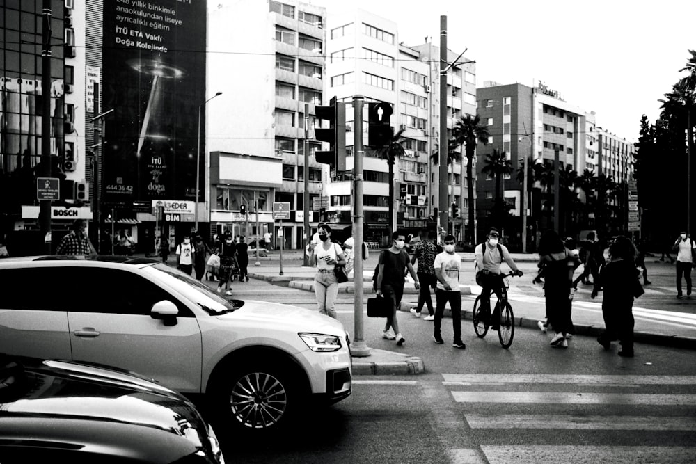 a black and white photo of people crossing the street