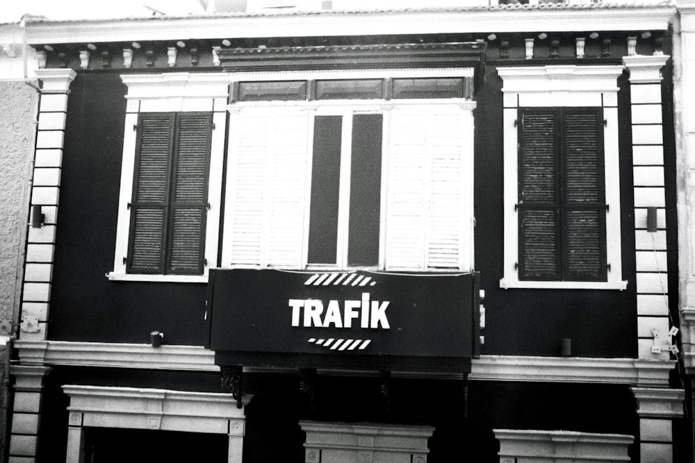 a black and white photo of a building with shutters