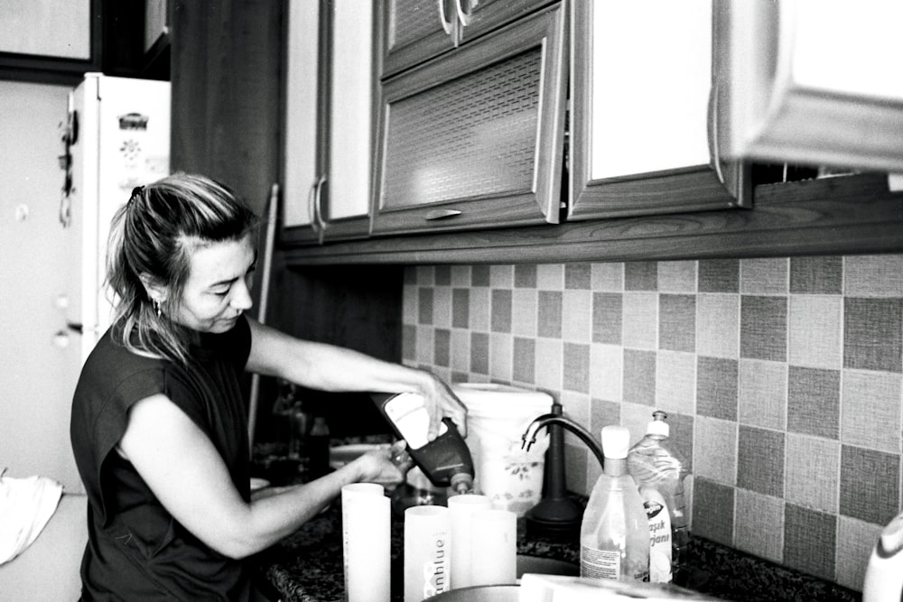 Una mujer está lavando platos en la cocina