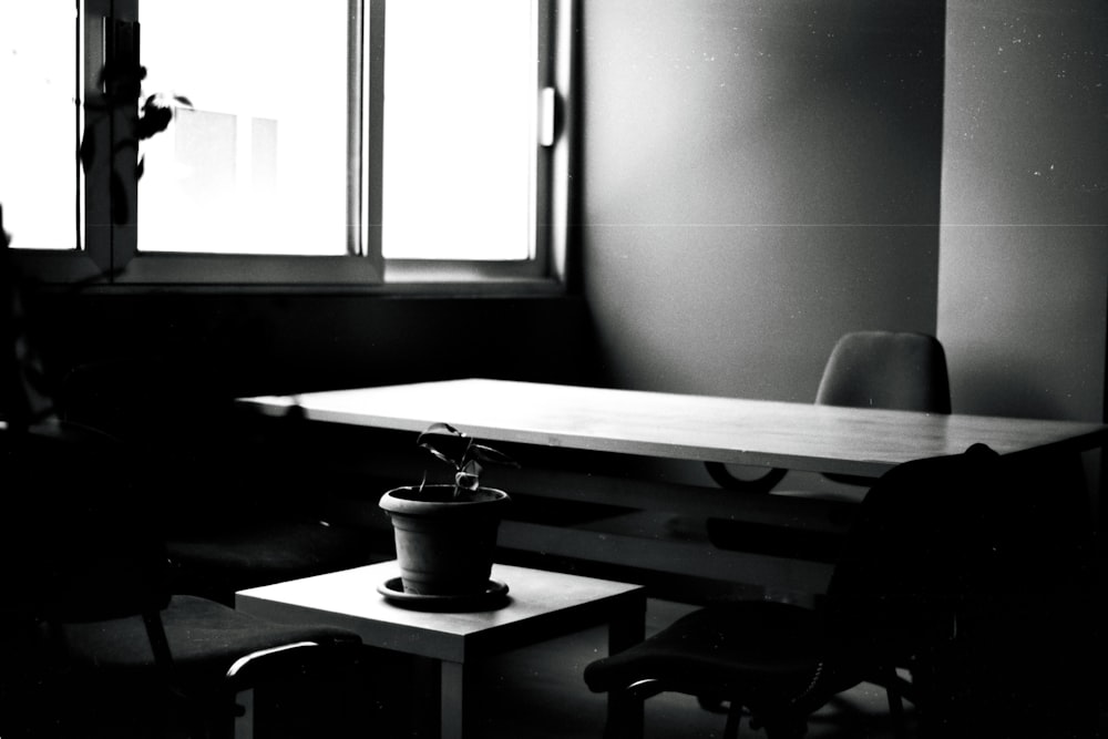 a black and white photo of a table and chairs