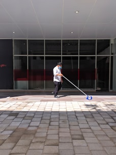 a man with a mop on a sidewalk