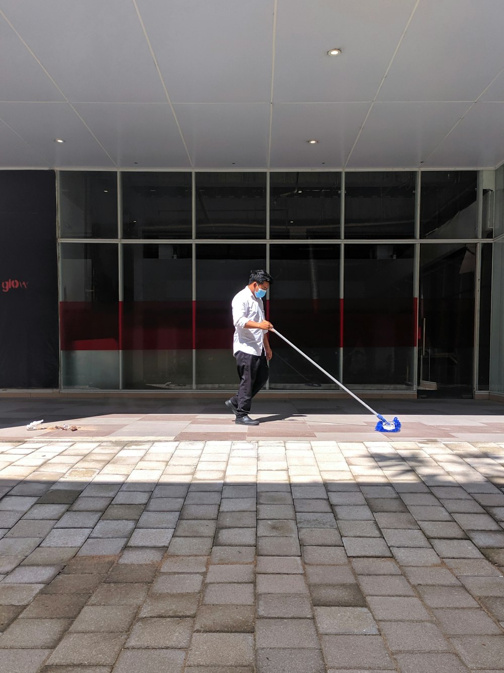 a man with a mop on a sidewalk