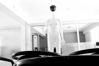 Minimalist workspace featuring a mannequin draped in a monochrome garment prototype.