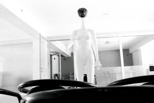 Wide shot of a minimalist atelier space with elegant garments displayed on mannequins.