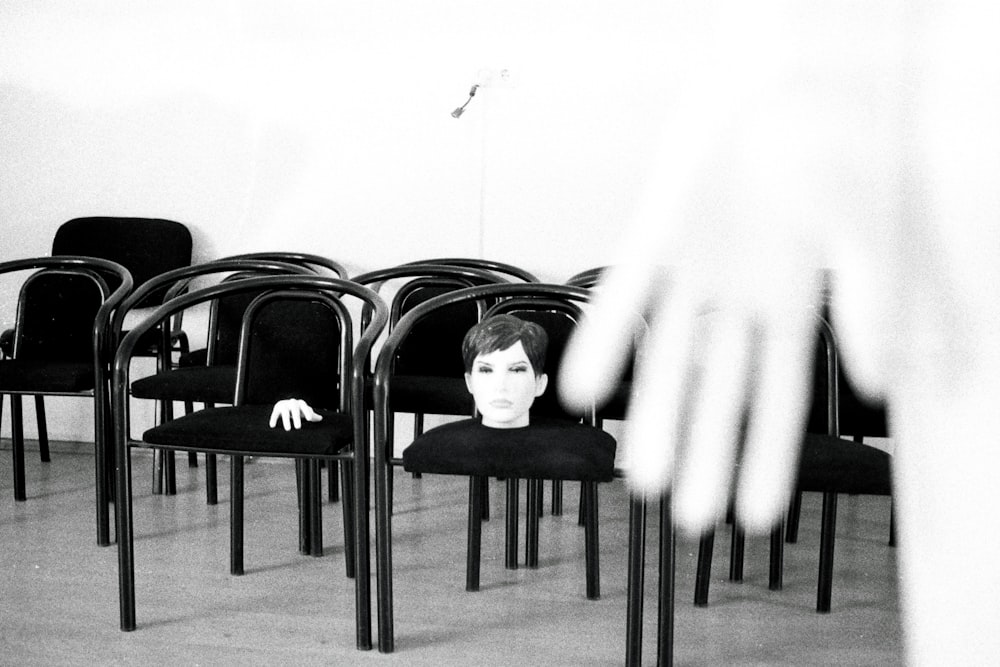 椅子に座っている女性の頭の白黒写真