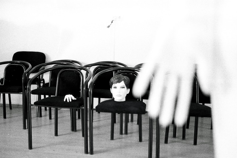 une photo en noir et blanc de la tête d’une femme sur une chaise