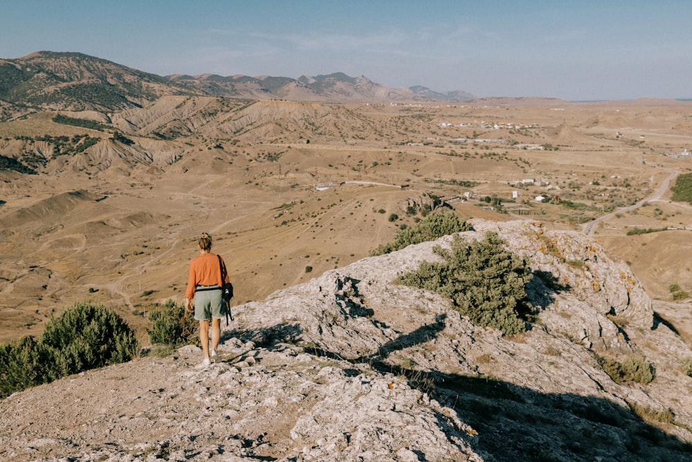 a man standing on top of a large rock