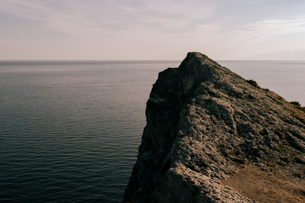 a person standing on top of a cliff near the ocean