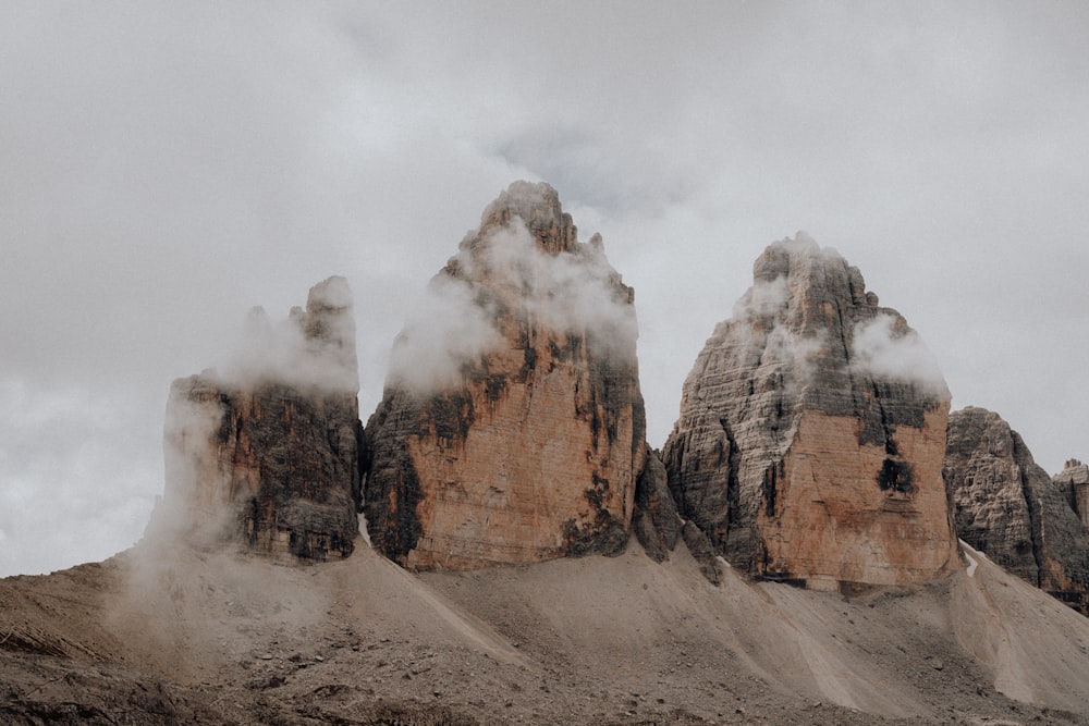 a group of mountains covered in clouds on a cloudy day