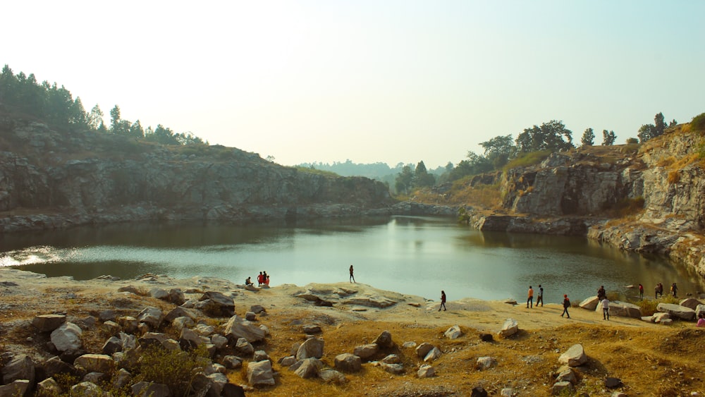 a group of people standing around a lake