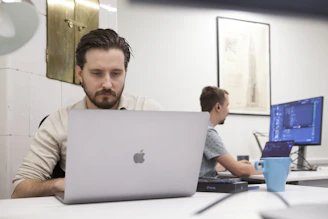 a man sitting in front of a laptop computer
