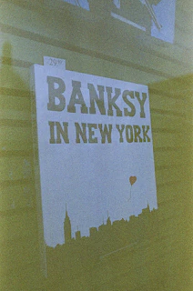 A gallery signboard listing exhibitions featuring Banksy’s works.