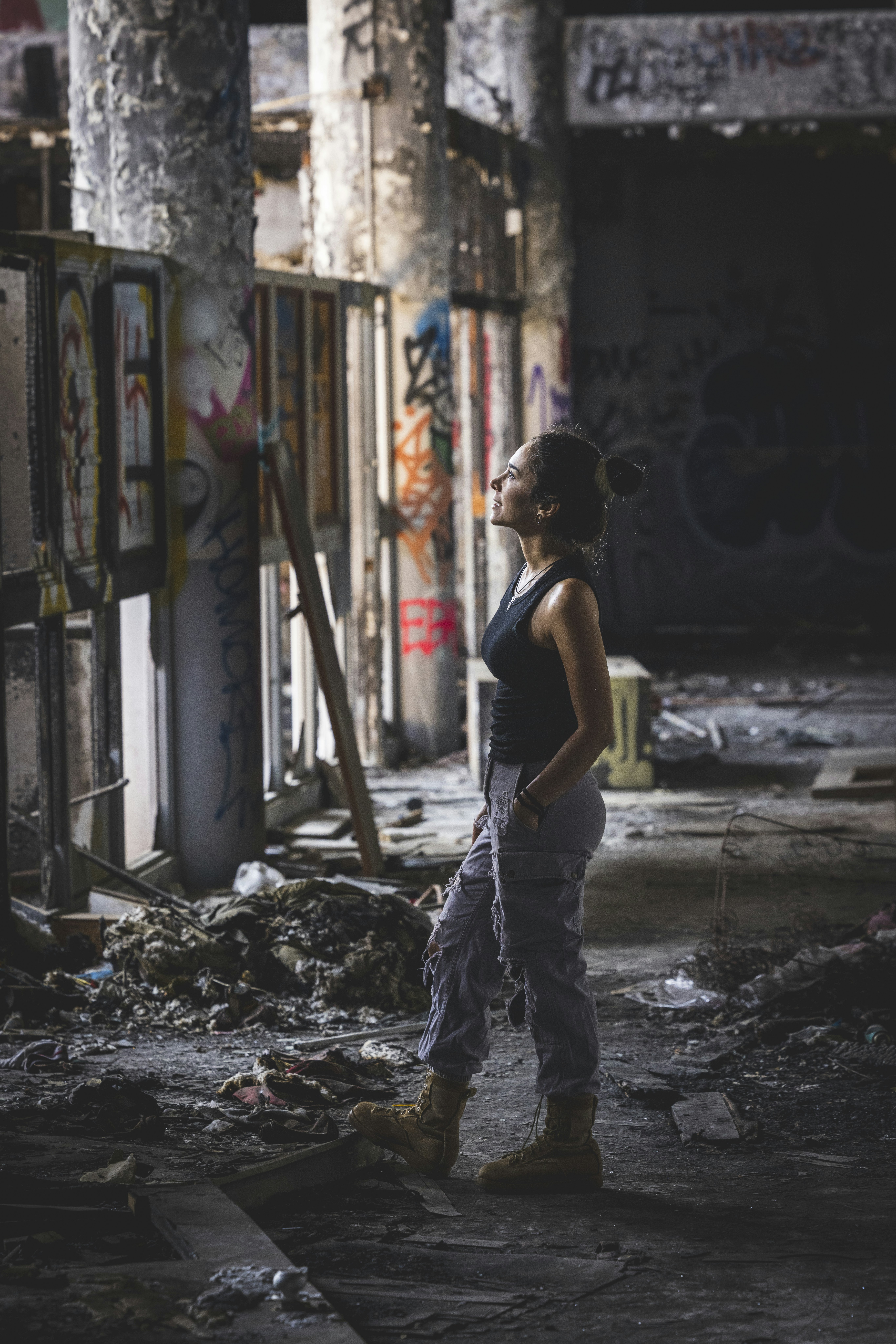 a woman standing in an alley with graffiti on the walls