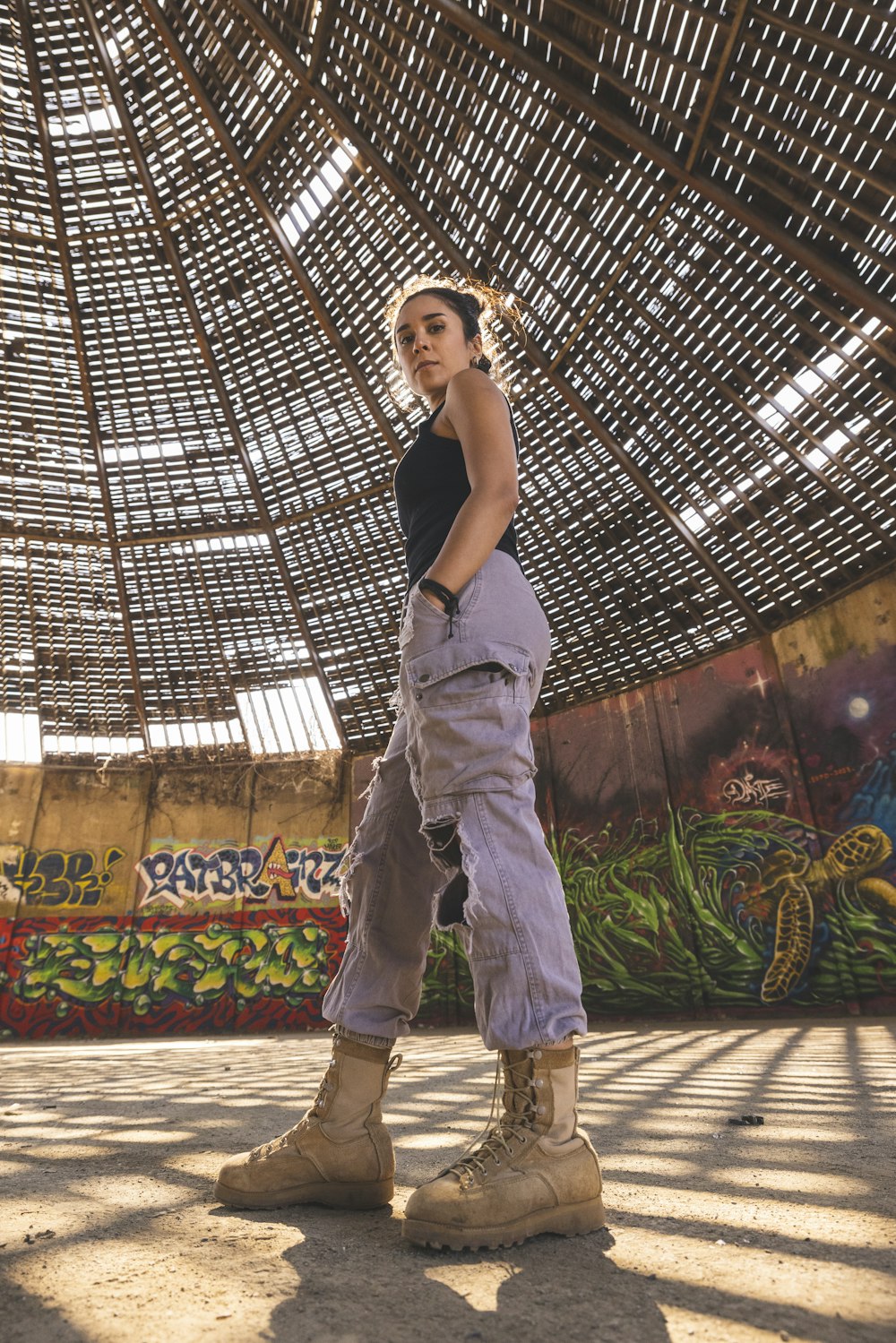 a woman standing in front of a bamboo structure