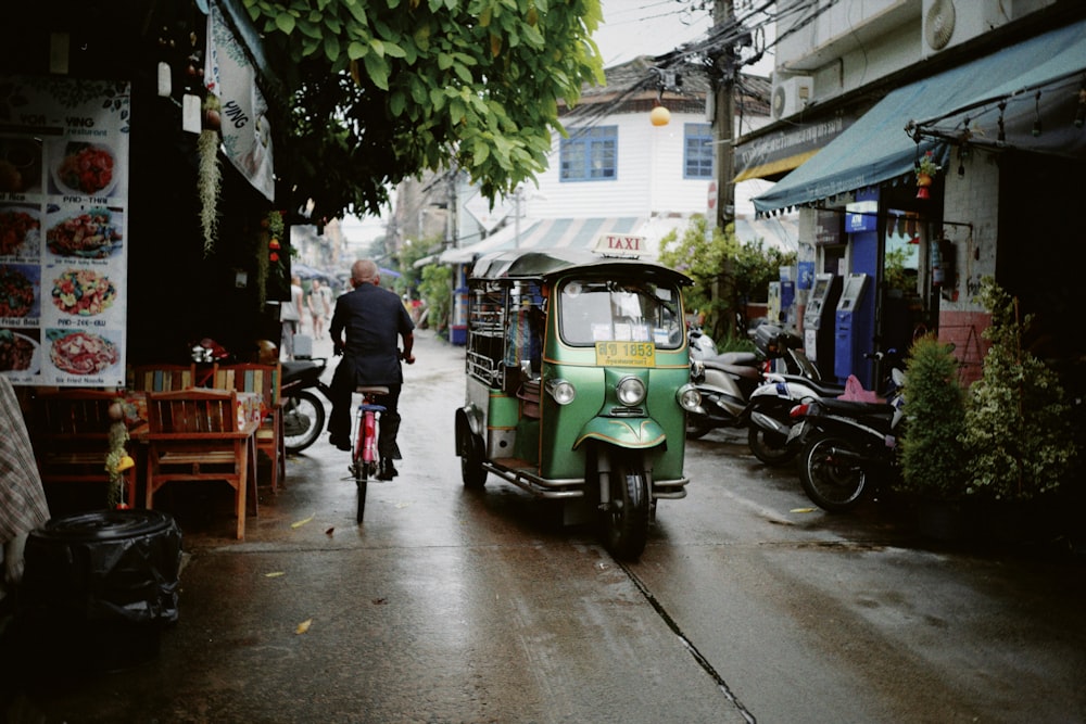 a man riding a bike down a wet street