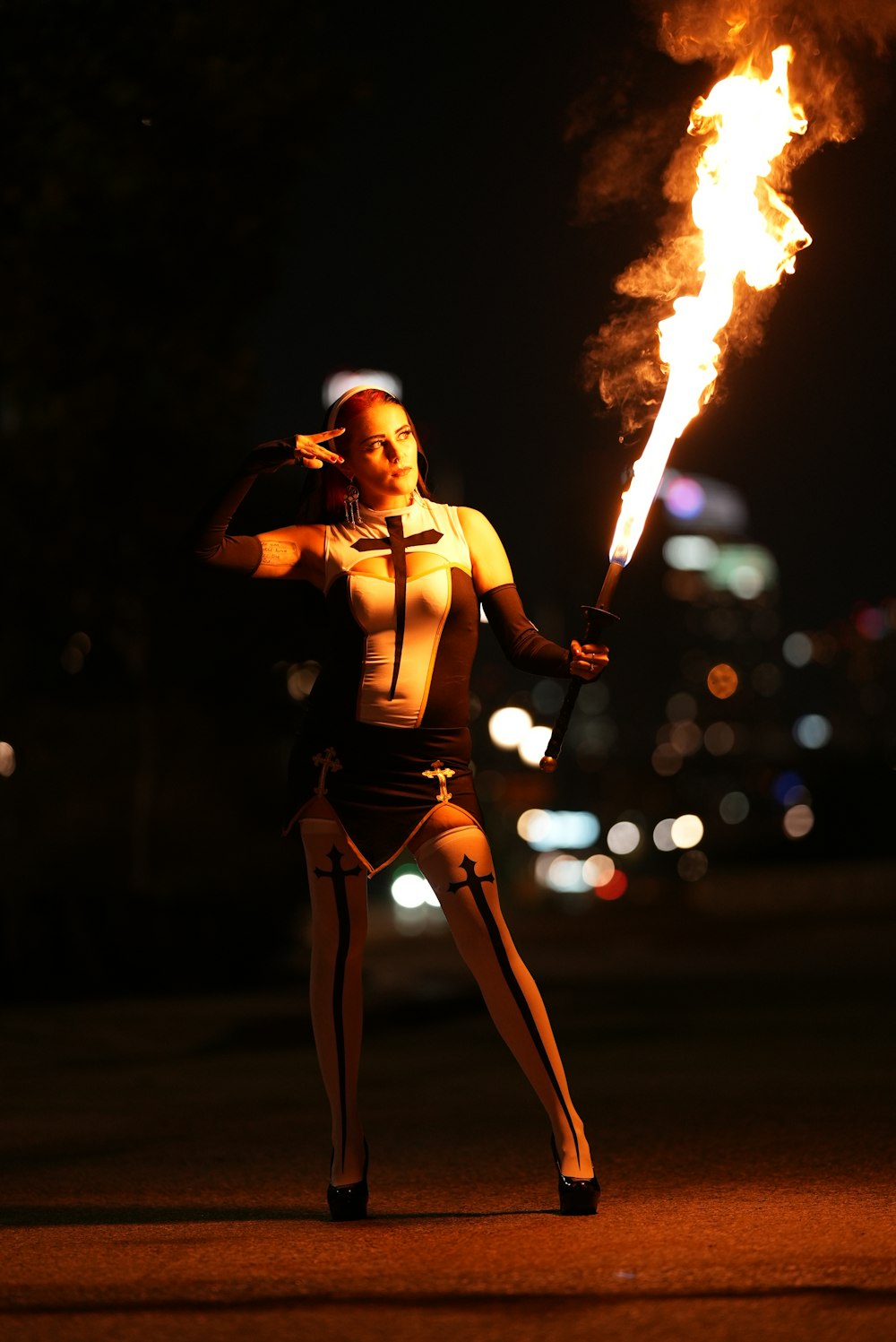 a woman holding a fire stick on a street
