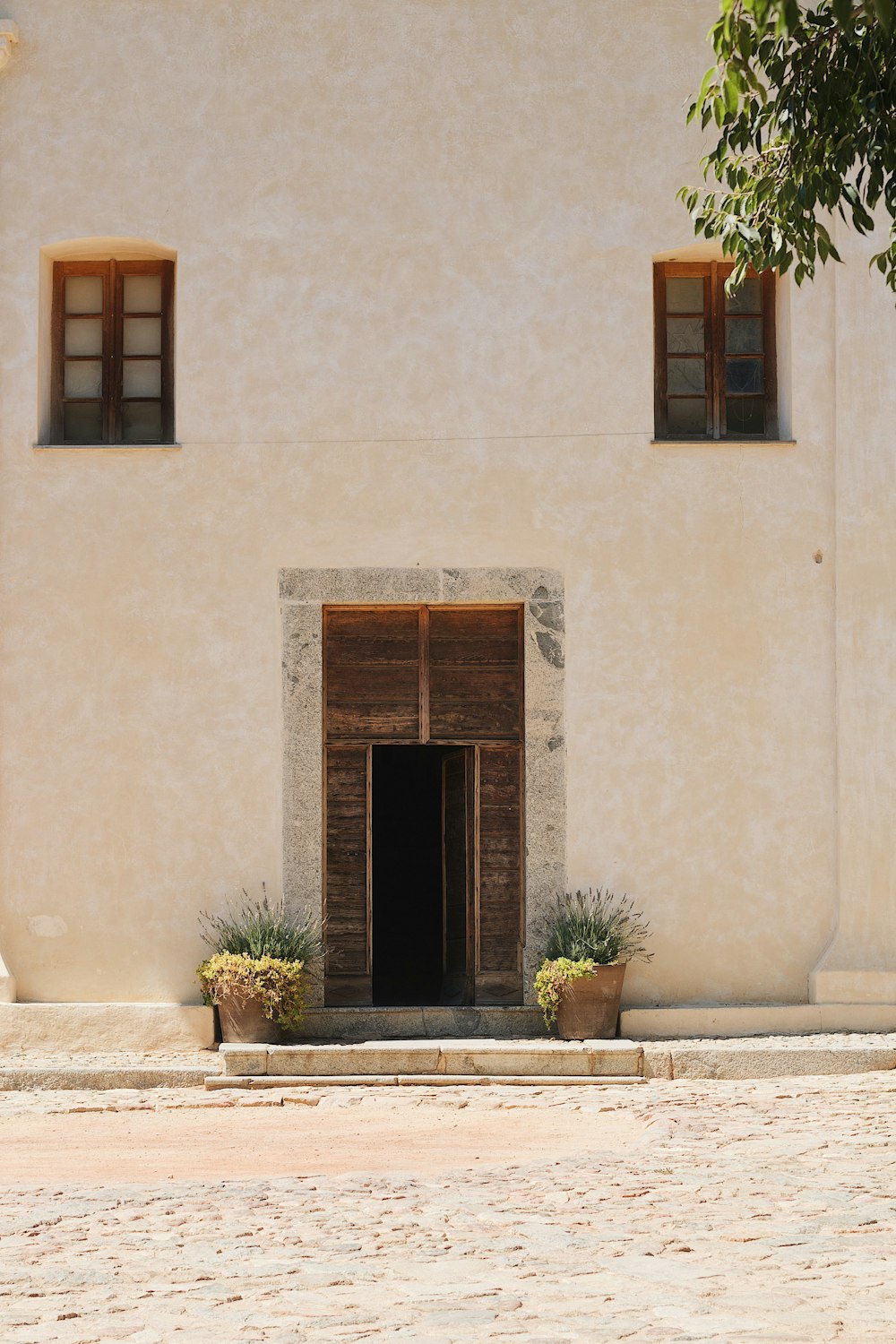 a white building with two windows and a door