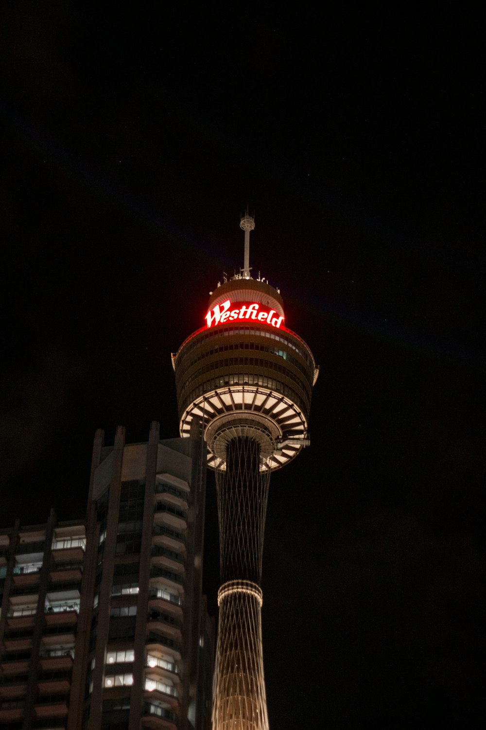 a tall tower with a red sign on top of it