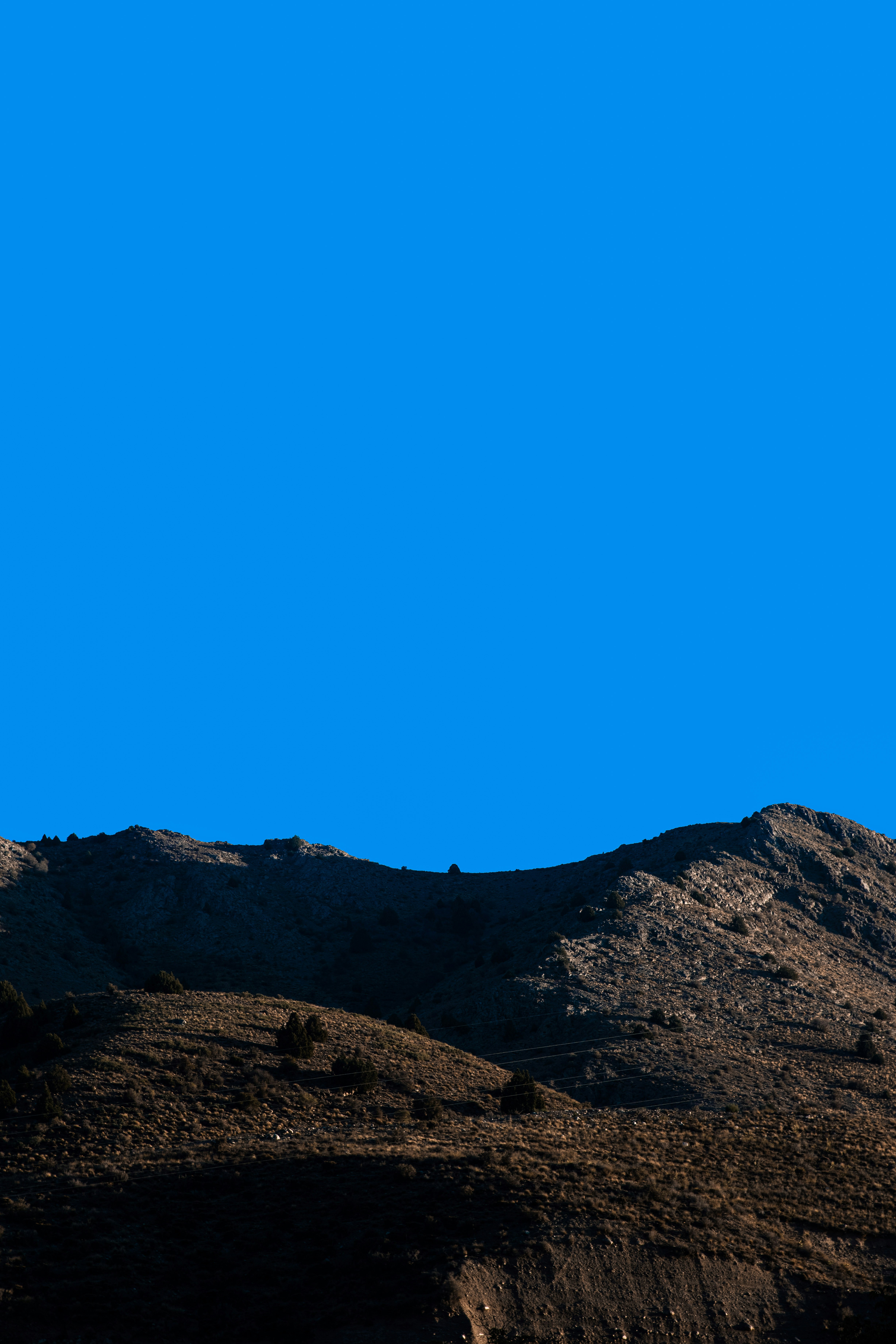 a plane flying over a mountain on a clear day