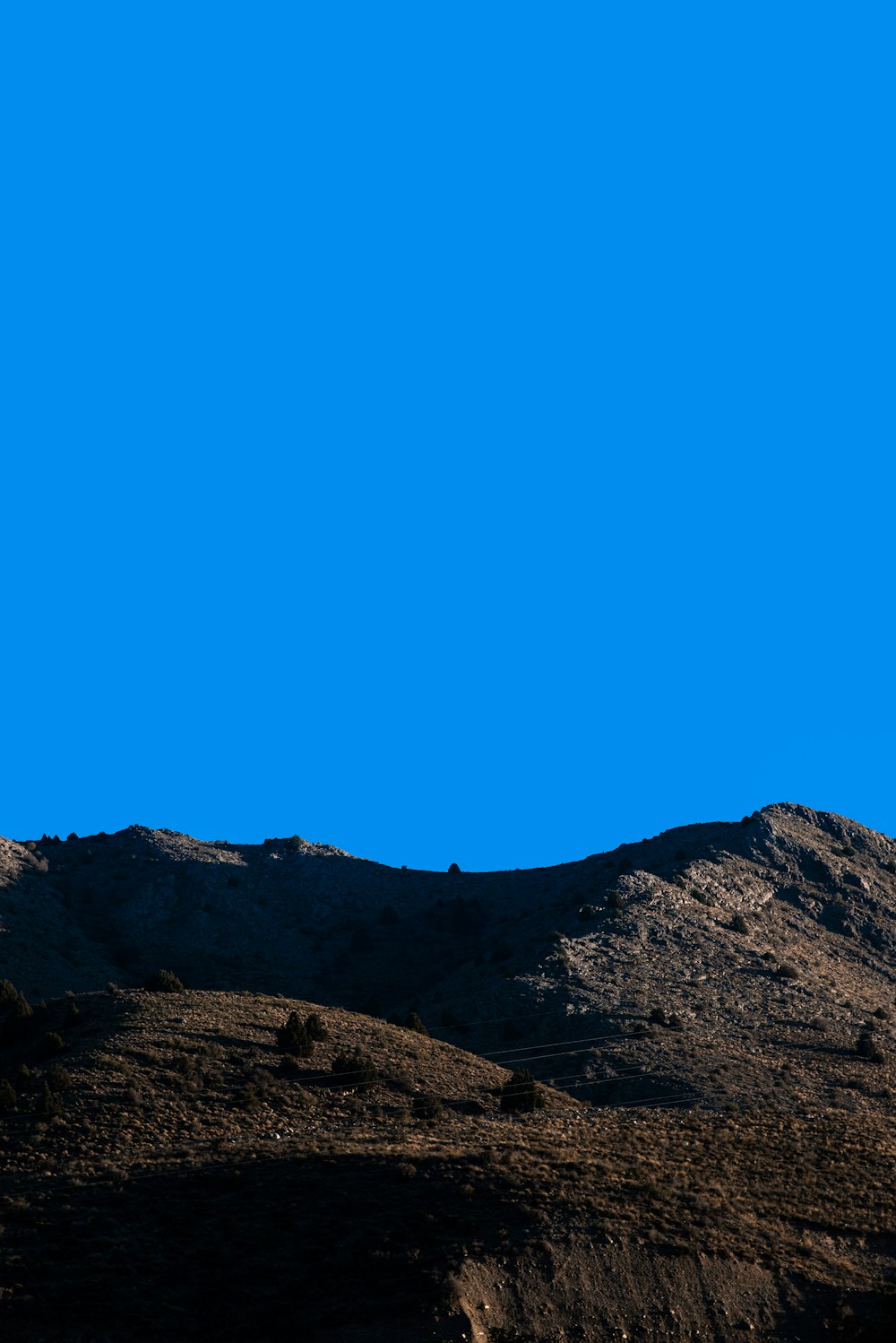 a plane flying over a mountain on a clear day