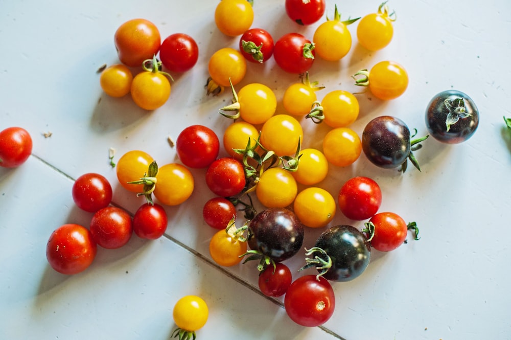 a bunch of different colored tomatoes on a table