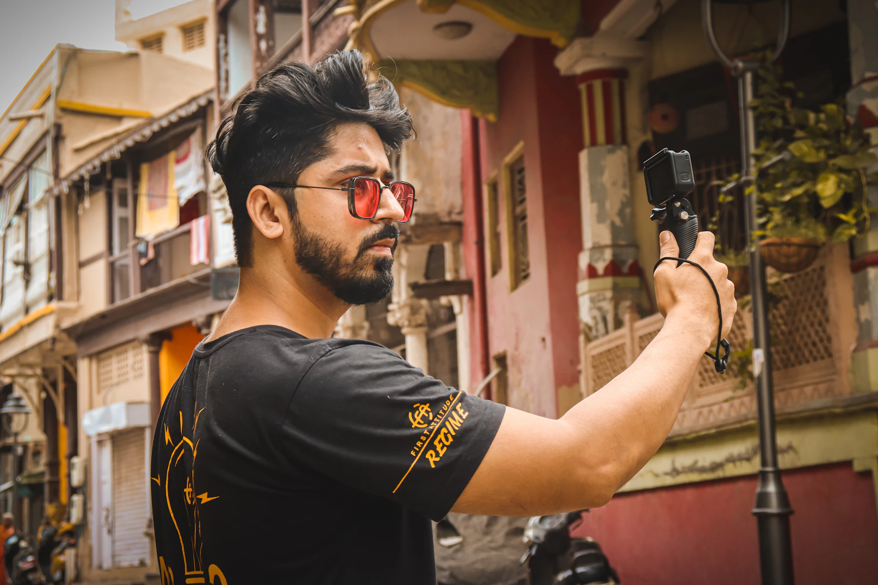 Indian creator filming a vlog on a phone gimbal in an old city street