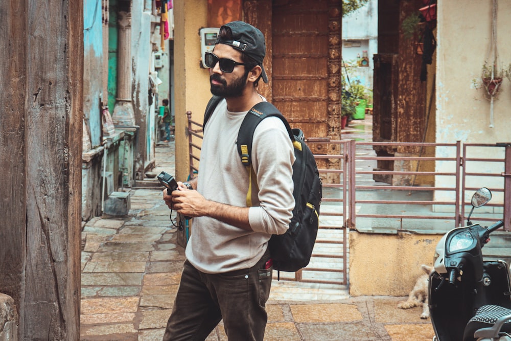 a man walking down a street holding a cell phone