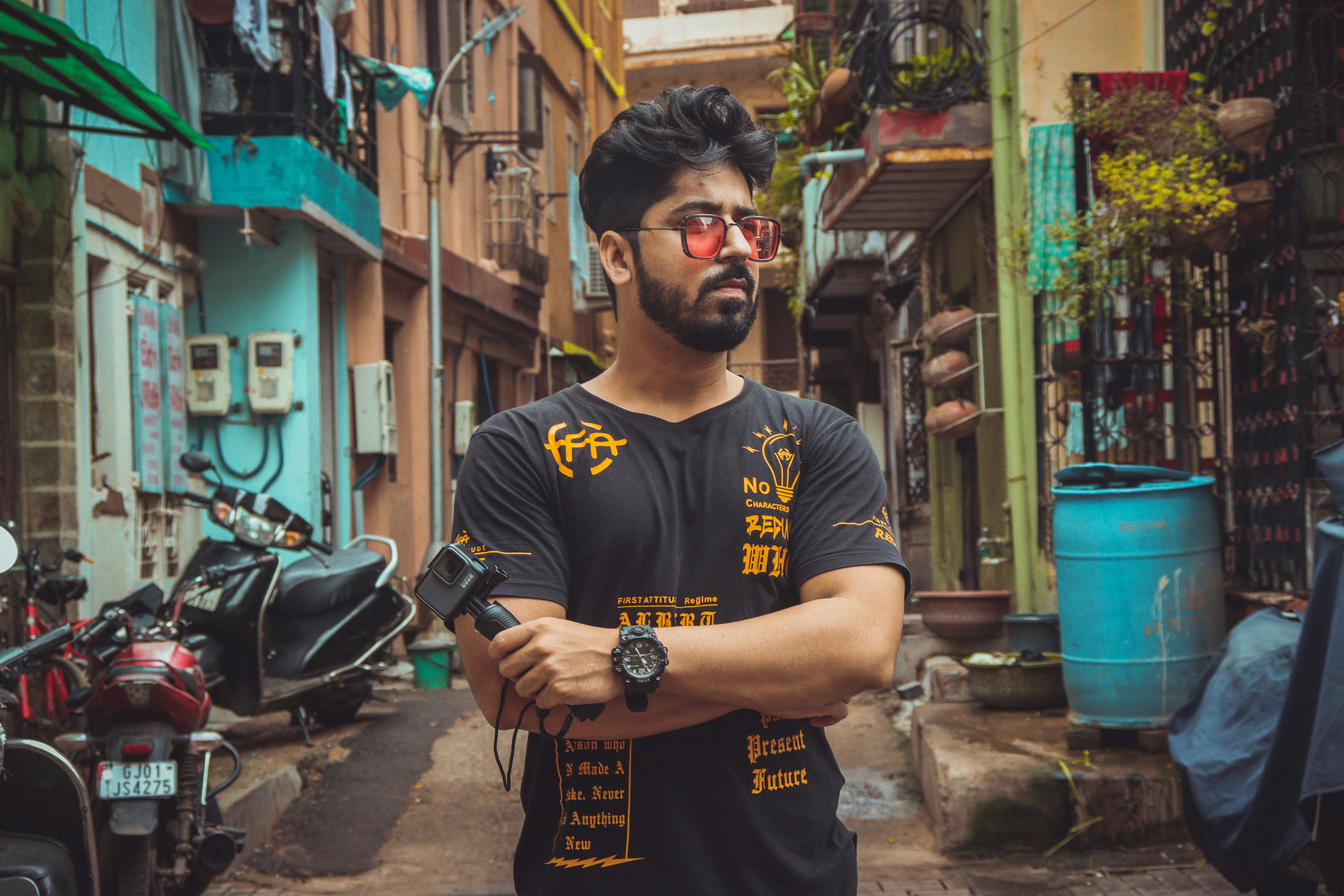 a man standing in an alley with his arms crossed