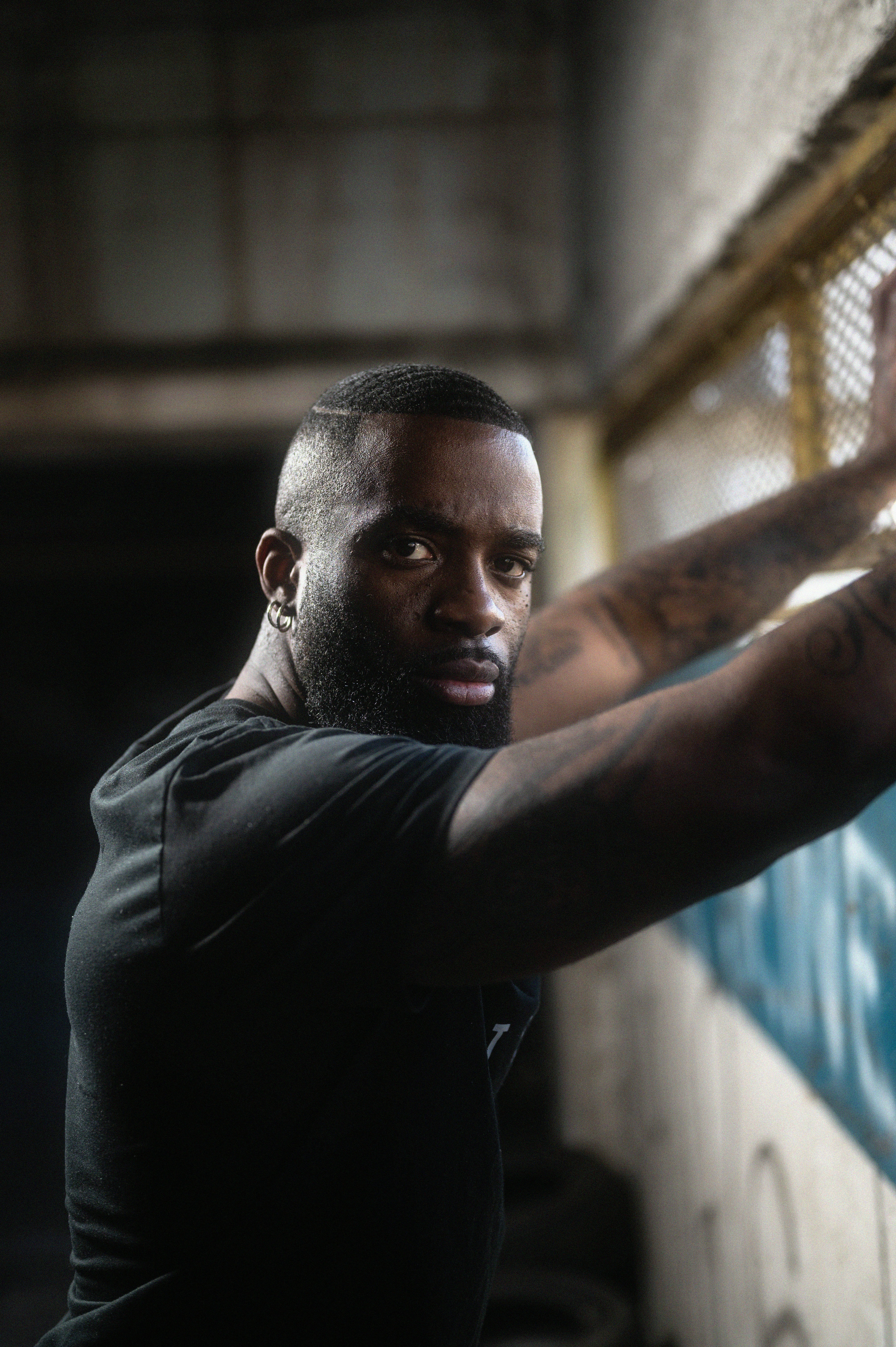 a man with tattoos on his arm holding a tennis racket