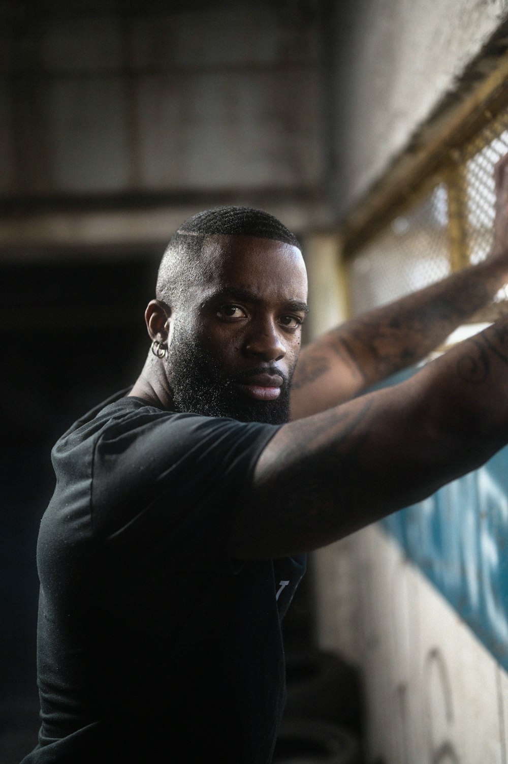 a man with tattoos on his arm holding a tennis racket