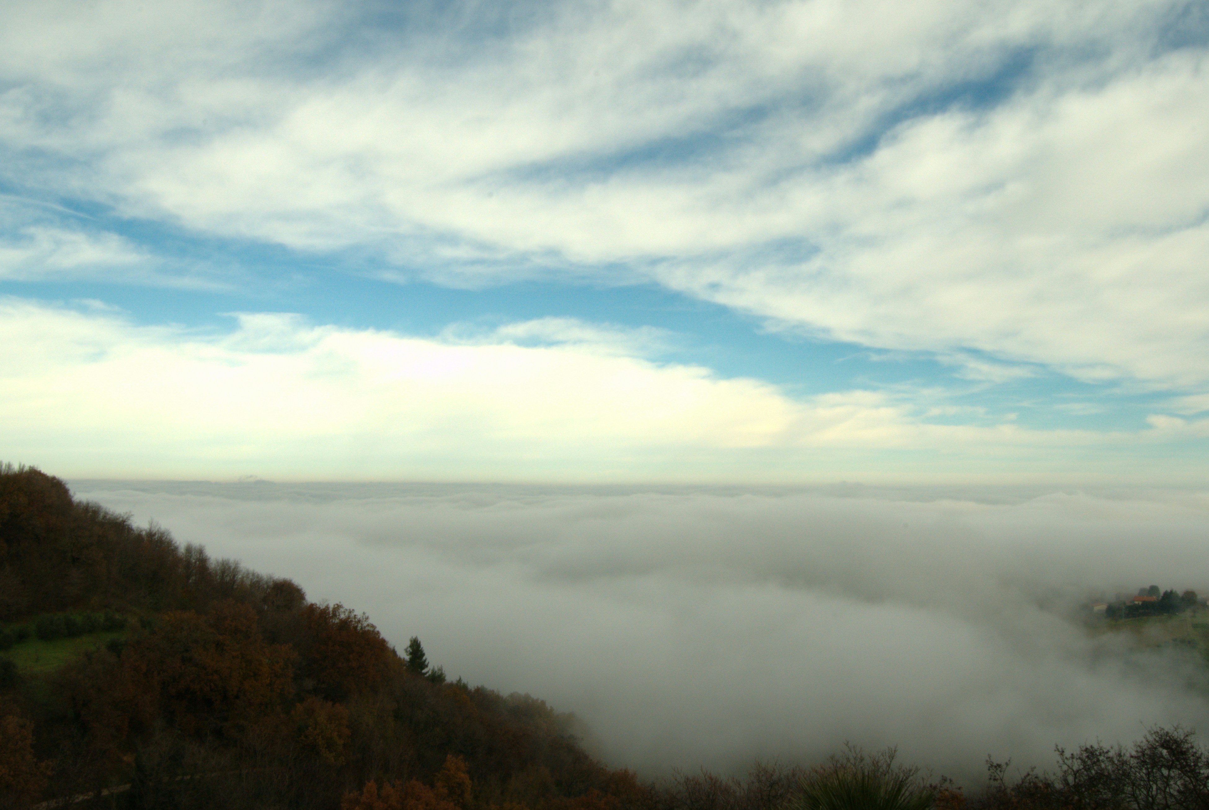 a view of a foggy valley from a hill
