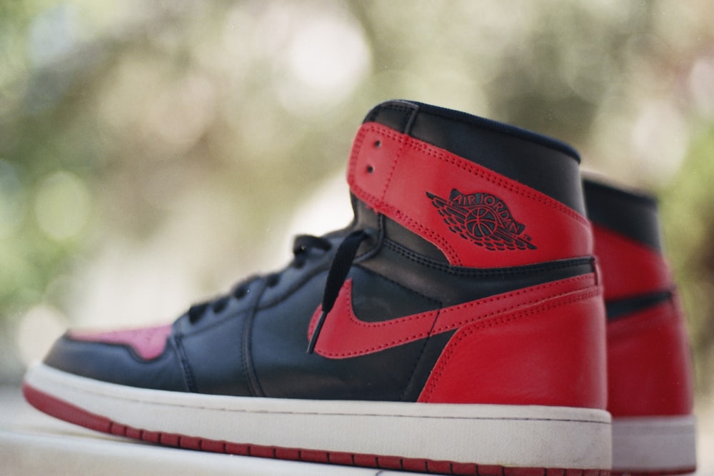 a pair of red and black sneakers sitting on top of a table