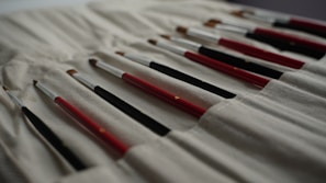 An array of brushes for art and office use displayed on a table.