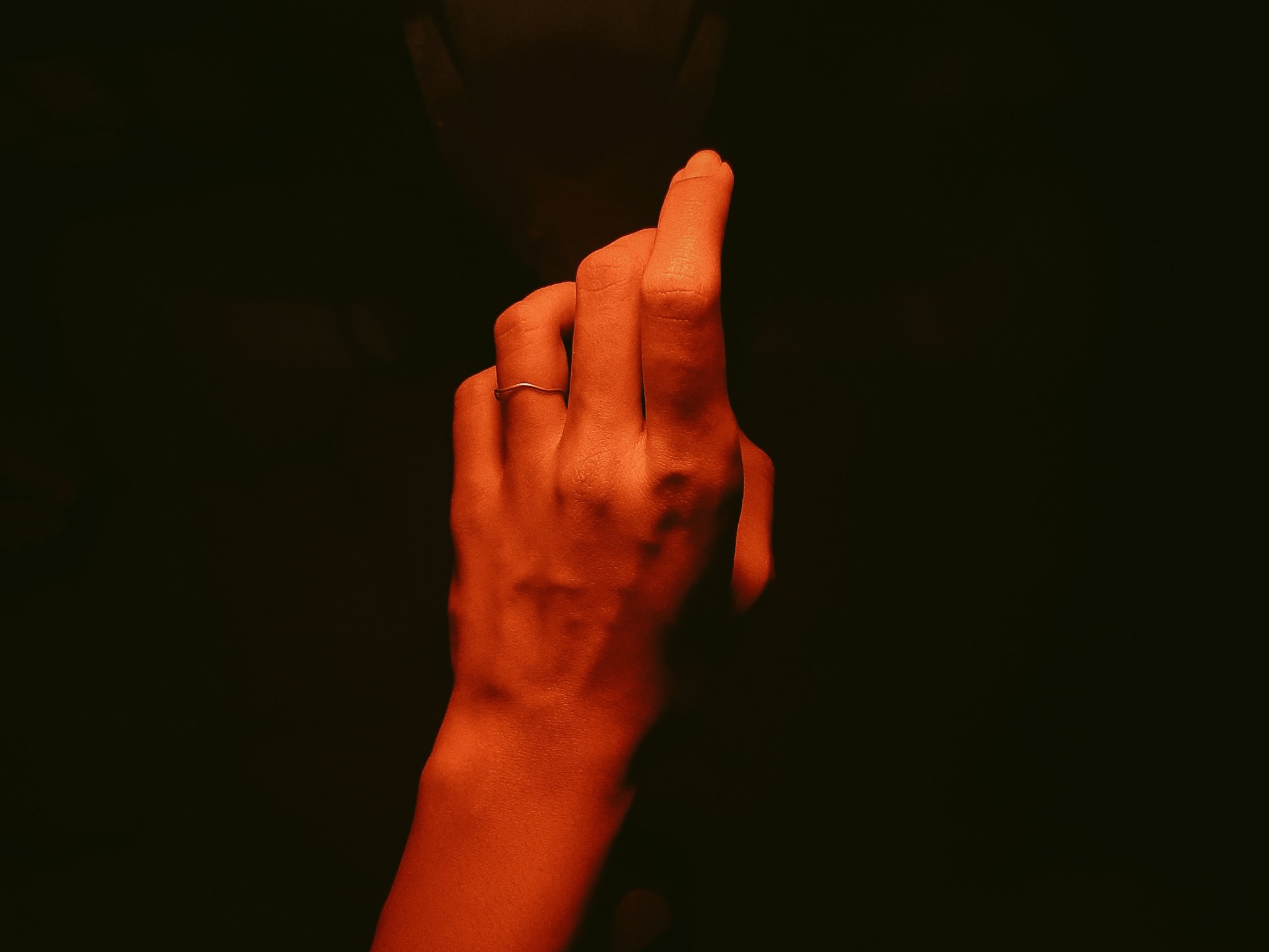 A hand demonstrating the gyan-mudra position wearing the enlightenring, with soft natural light emphasizing the ring's subtle glow.