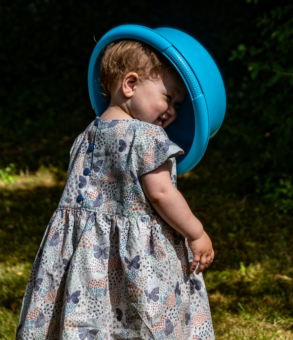 a little girl with a blue frisbee on her head