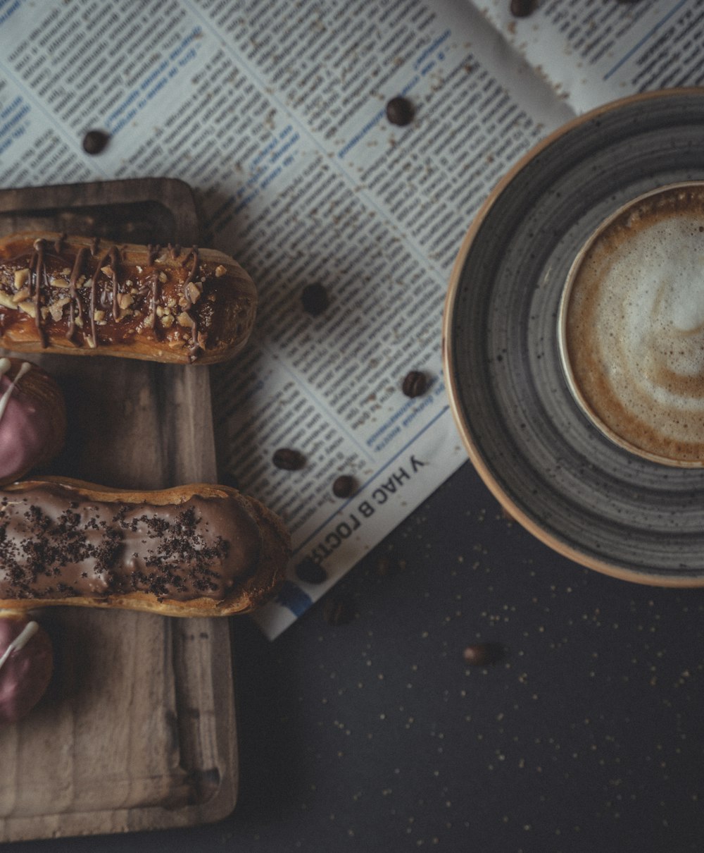 a couple of doughnuts on a tray next to a cup of coffee