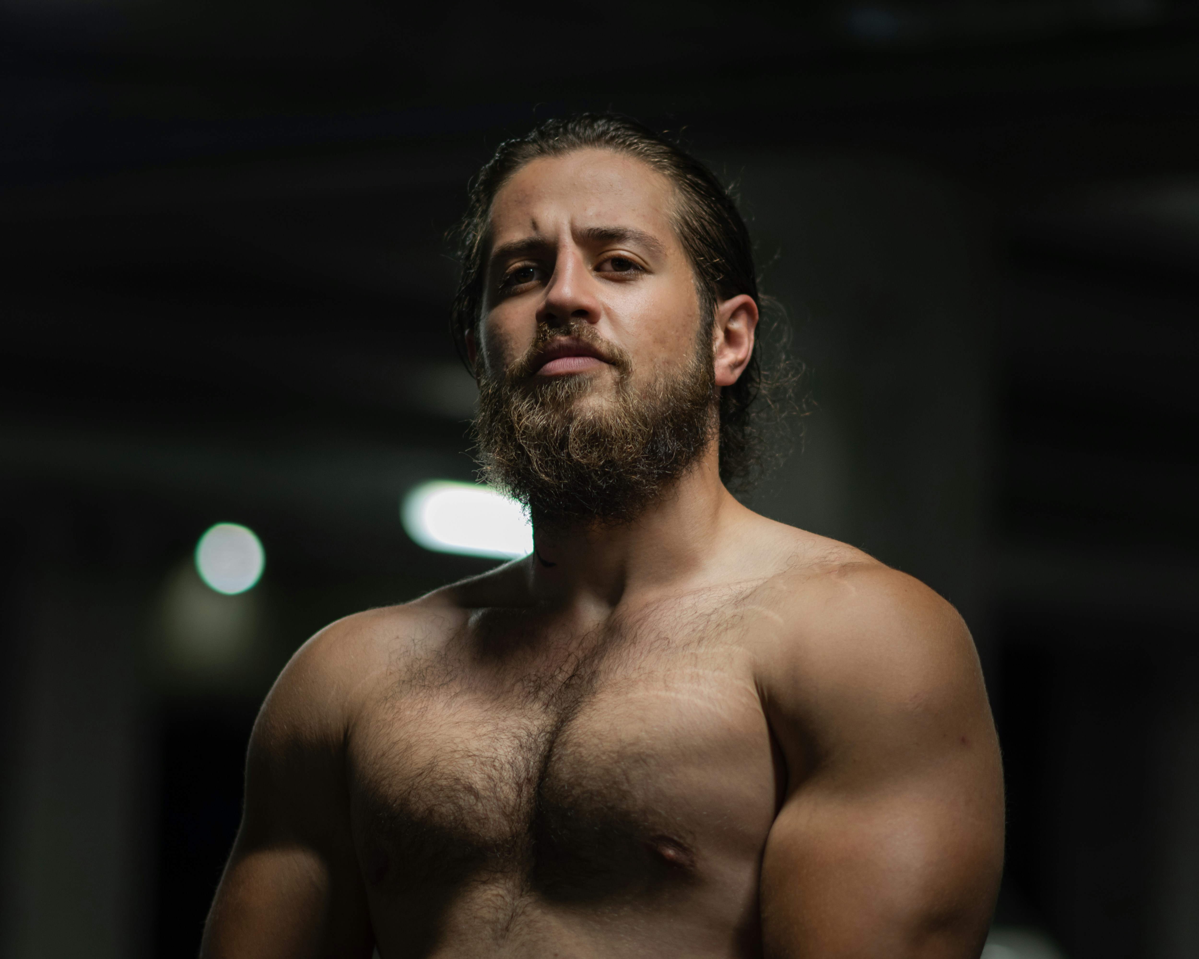Fitness professional portrait - shirtless man in dark room