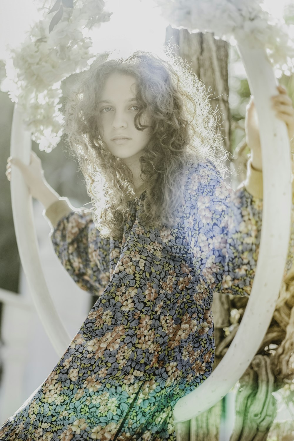 a woman in a floral dress holding a flower