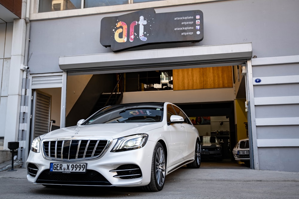 a white car parked in front of a garage