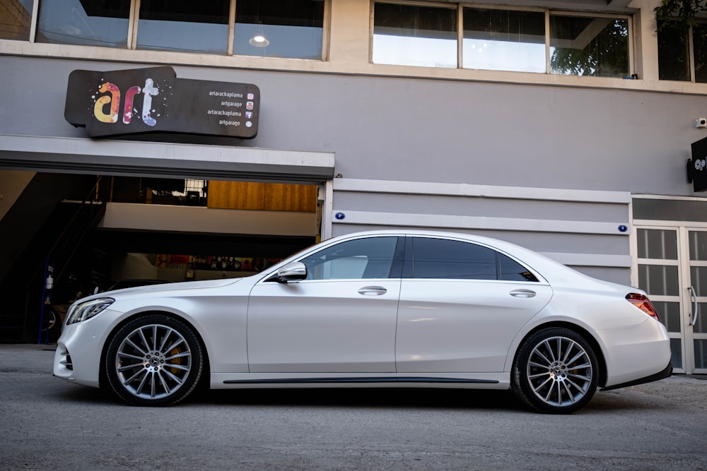 a white car parked in front of a building