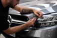 a man waxing the hood of a car