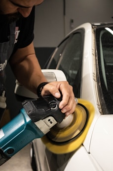 a man sanding a car with a sander