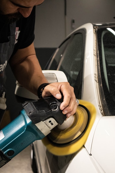 a man sanding a car with a sander