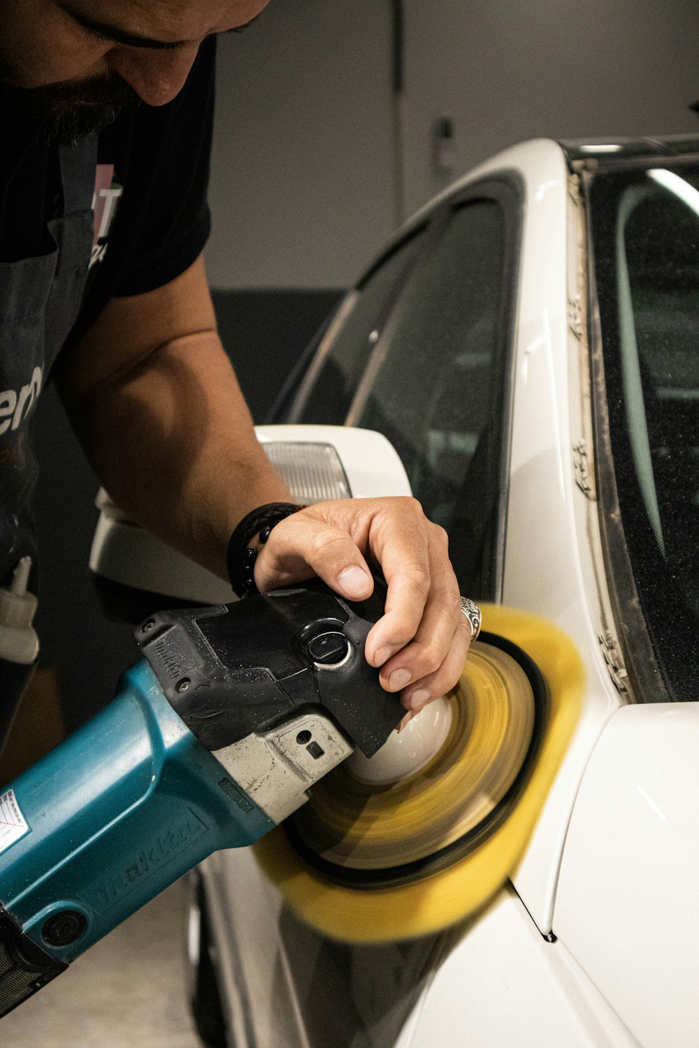 a man sanding a car with a sander