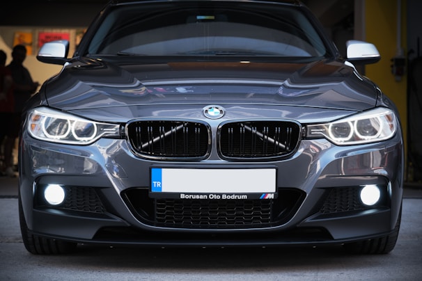 the front of a silver bmw car parked in a garage