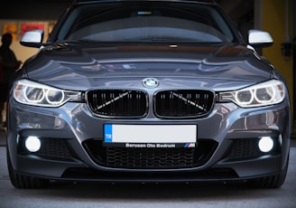 the front of a silver bmw car parked in a garage